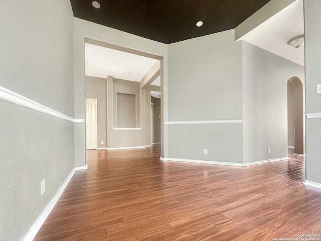 empty room featuring hardwood / wood-style floors and wooden ceiling