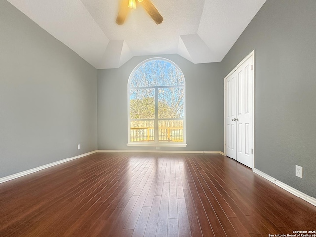 unfurnished room featuring vaulted ceiling, dark hardwood / wood-style floors, and ceiling fan