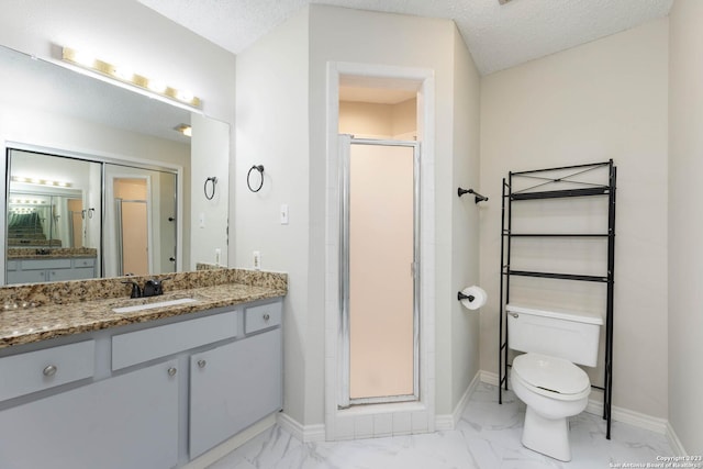 bathroom with vanity, toilet, a textured ceiling, and a shower with shower door