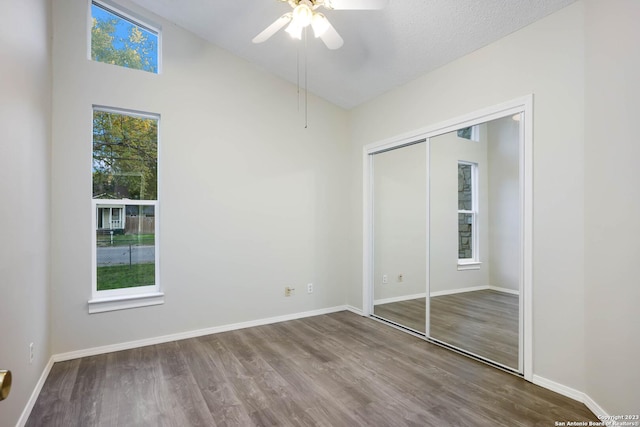 unfurnished bedroom featuring hardwood / wood-style flooring, vaulted ceiling, a closet, and ceiling fan