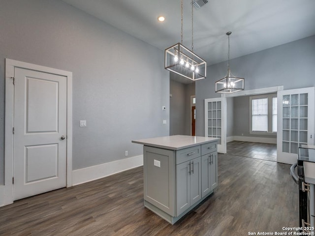 kitchen with hanging light fixtures, a center island, a notable chandelier, and dark hardwood / wood-style flooring