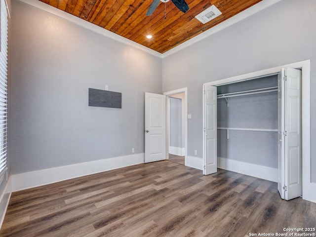 unfurnished bedroom with dark hardwood / wood-style floors, wooden ceiling, and a closet