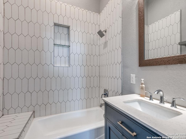 bathroom with tiled shower / bath and vanity