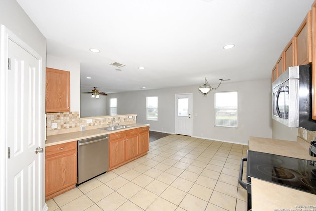 kitchen with sink, ceiling fan, appliances with stainless steel finishes, backsplash, and light tile patterned flooring