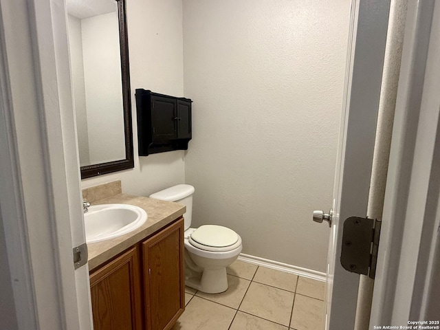 bathroom featuring vanity, tile patterned floors, and toilet