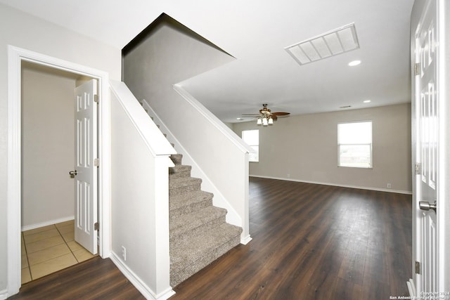 stairway with hardwood / wood-style floors and ceiling fan