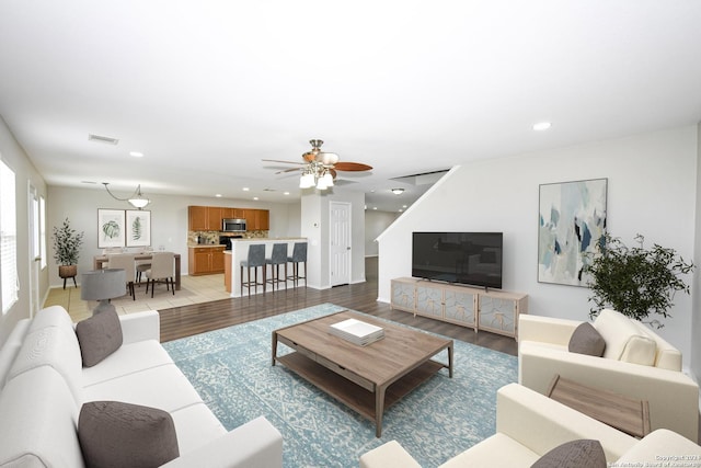 living room with light hardwood / wood-style flooring and ceiling fan