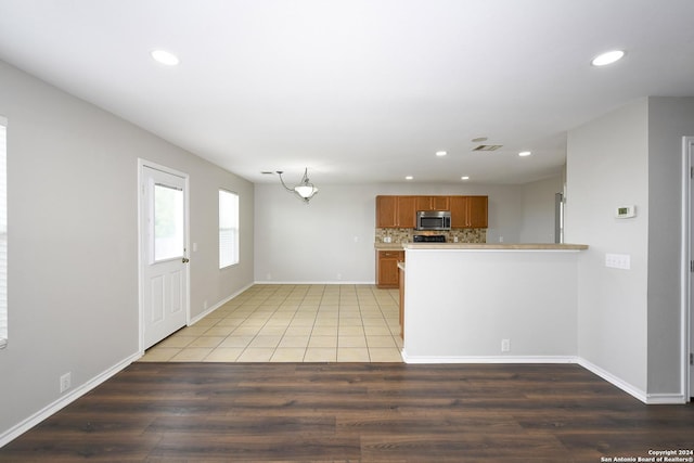 kitchen featuring tasteful backsplash, kitchen peninsula, and hardwood / wood-style floors