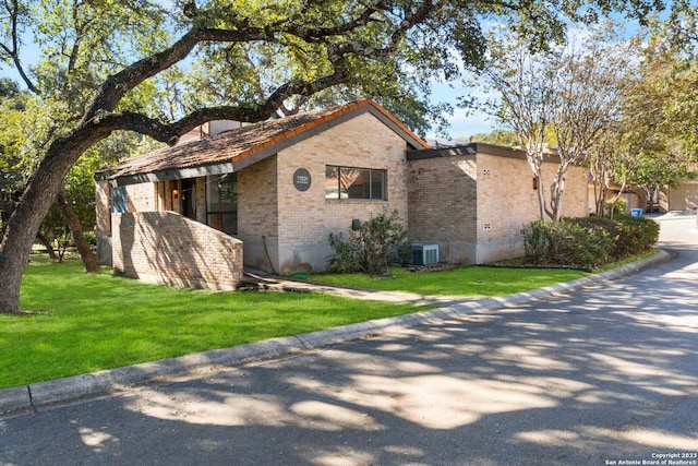 view of side of property featuring central AC and a lawn