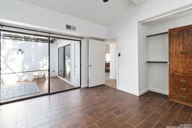 unfurnished bedroom with lofted ceiling and a closet