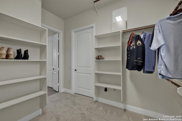 spacious closet featuring light colored carpet