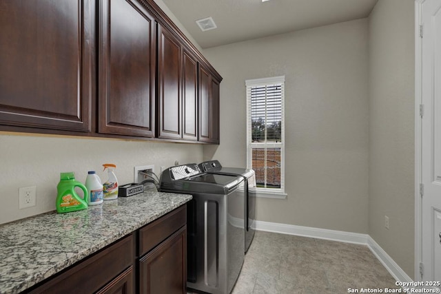 washroom featuring cabinets and washing machine and clothes dryer