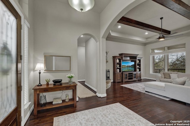 living room with beamed ceiling, dark hardwood / wood-style floors, and ceiling fan