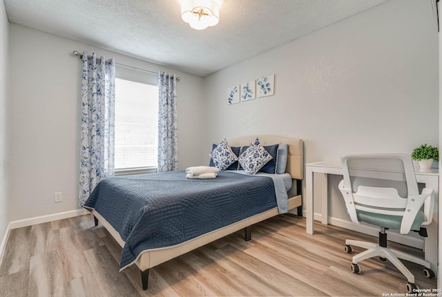 bedroom featuring wood-type flooring and a textured ceiling