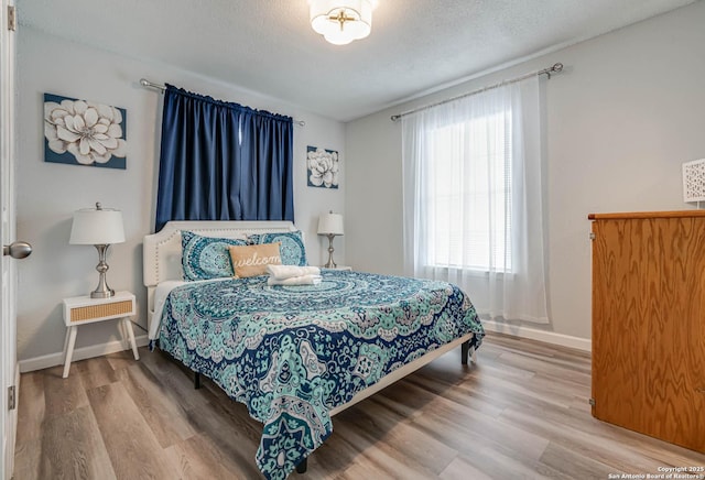 bedroom featuring hardwood / wood-style floors and a textured ceiling