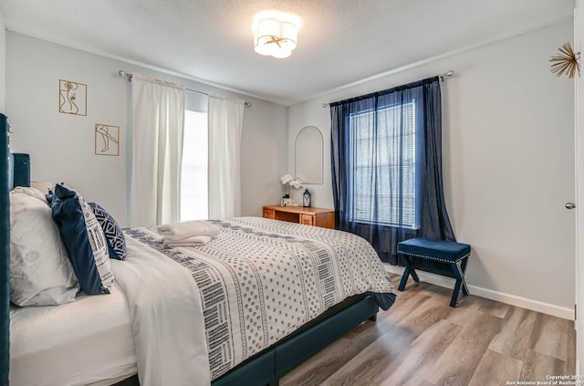 bedroom featuring hardwood / wood-style flooring and a textured ceiling