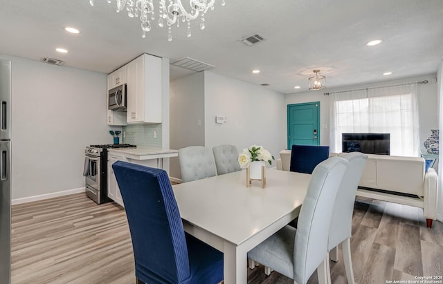 dining room featuring an inviting chandelier and light hardwood / wood-style flooring