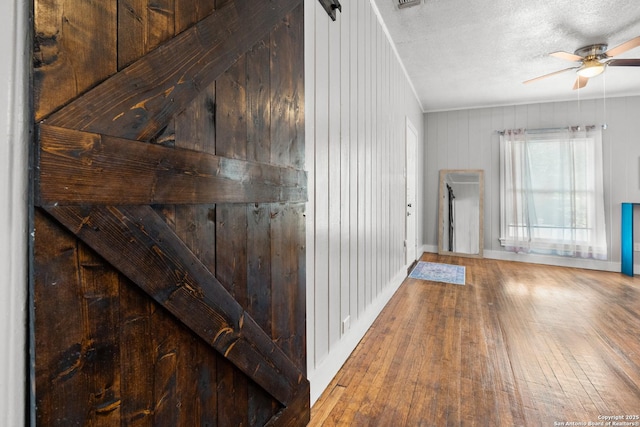 hallway with hardwood / wood-style flooring and a textured ceiling