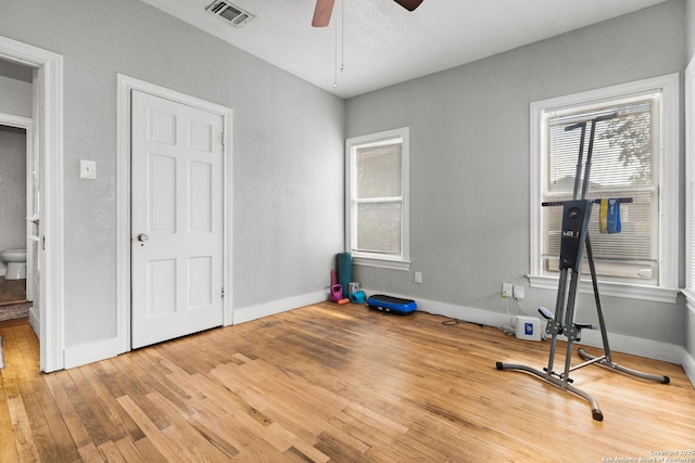 exercise area with ceiling fan and wood-type flooring