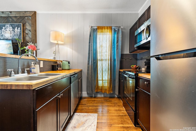 kitchen with appliances with stainless steel finishes, sink, and dark brown cabinets