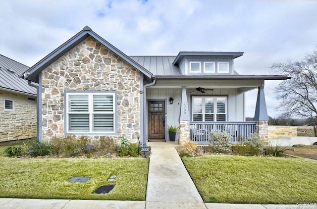 view of front of house with ceiling fan, covered porch, and a front yard