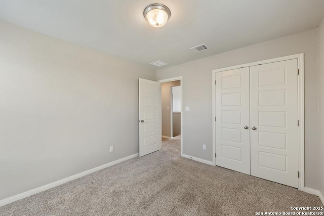 unfurnished bedroom featuring light carpet and a closet