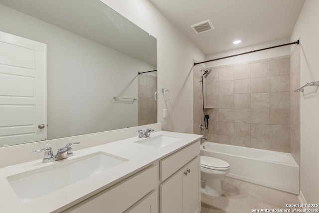 full bathroom featuring tiled shower / bath combo, vanity, tile patterned flooring, and toilet