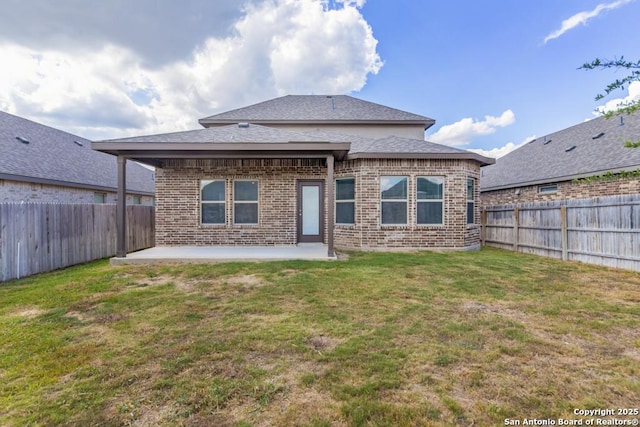 rear view of house featuring a lawn and a patio