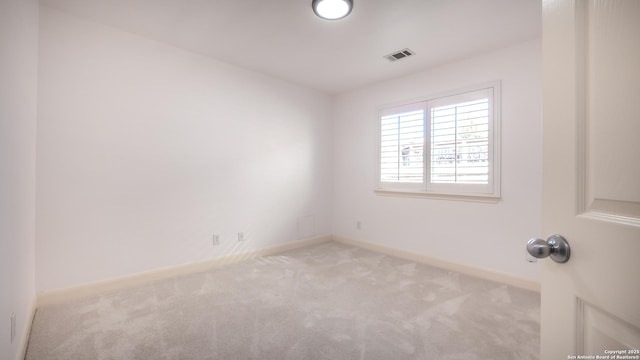 spare room featuring light colored carpet