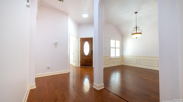 entryway with lofted ceiling, crown molding, and dark hardwood / wood-style floors