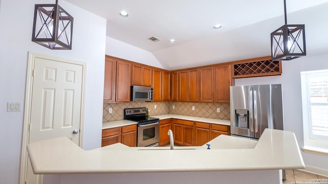 kitchen with lofted ceiling, sink, tasteful backsplash, appliances with stainless steel finishes, and pendant lighting