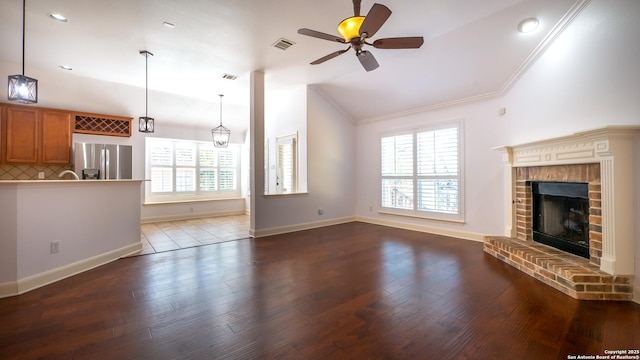 unfurnished living room featuring vaulted ceiling, plenty of natural light, and hardwood / wood-style floors