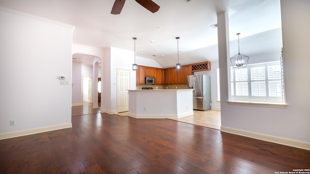 unfurnished living room featuring lofted ceiling, ceiling fan with notable chandelier, and light wood-type flooring