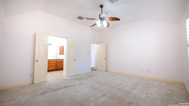 unfurnished bedroom featuring light carpet, connected bathroom, high vaulted ceiling, and ceiling fan