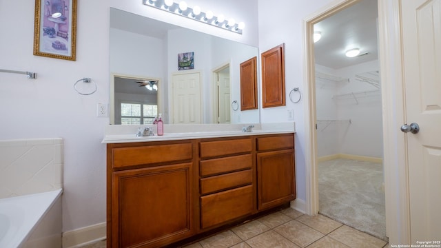 bathroom with tile patterned flooring, vanity, and a washtub