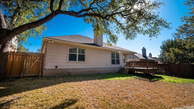 back of property featuring a yard and a deck