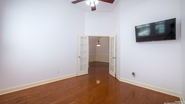 empty room featuring dark hardwood / wood-style floors, ornamental molding, french doors, and ceiling fan