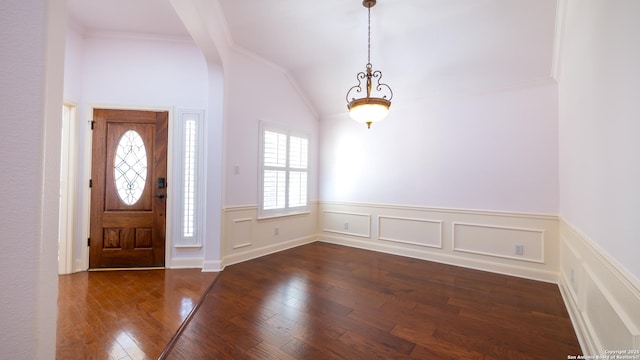 entryway with vaulted ceiling, ornamental molding, and dark hardwood / wood-style floors