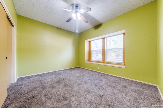 carpeted empty room with ceiling fan and a textured ceiling