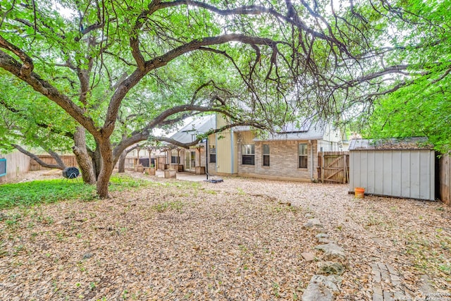 9018 Brickwood, San Antonio, TX 78250 - back of house featuring a fenced backyard, an outdoor structure, a patio area, and brick siding