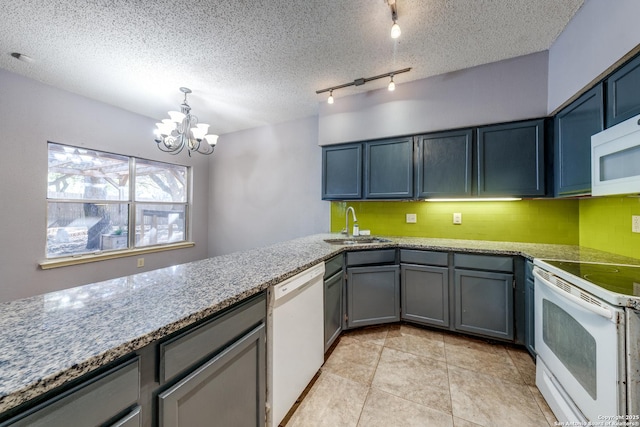 kitchen featuring sink, a textured ceiling, pendant lighting, white appliances, and backsplash