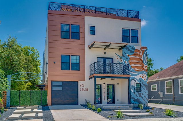 view of front of home featuring french doors, a balcony, and a garage