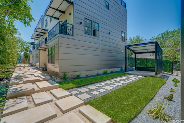 view of home's exterior featuring a yard, a gazebo, and a balcony