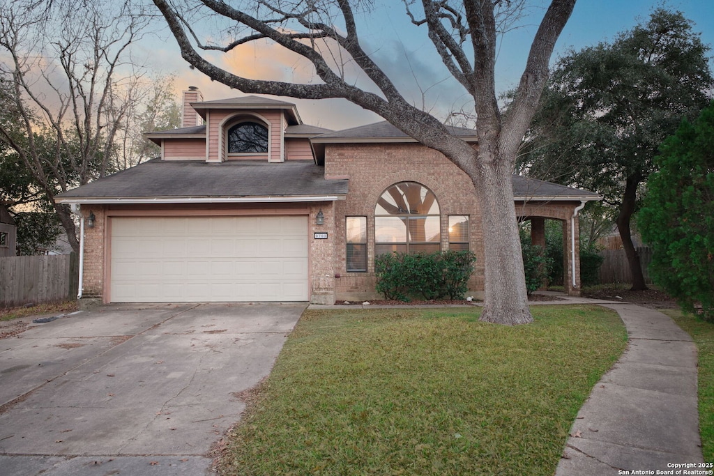 view of front of property featuring a garage and a yard