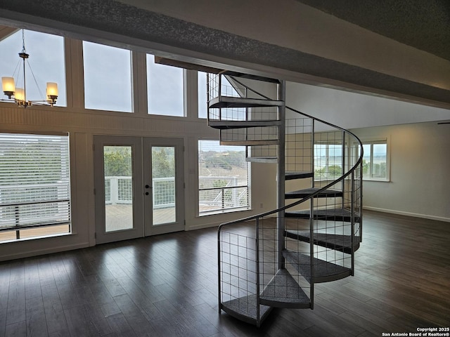 interior space with a notable chandelier, hardwood / wood-style flooring, vaulted ceiling with beams, and french doors