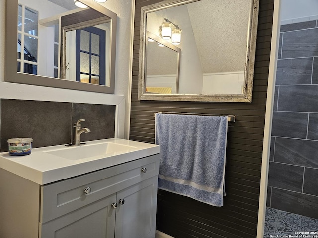 bathroom featuring vanity, a textured ceiling, and backsplash