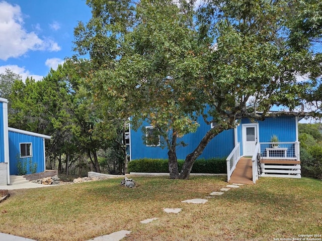 view of front of home with a wooden deck and a front lawn