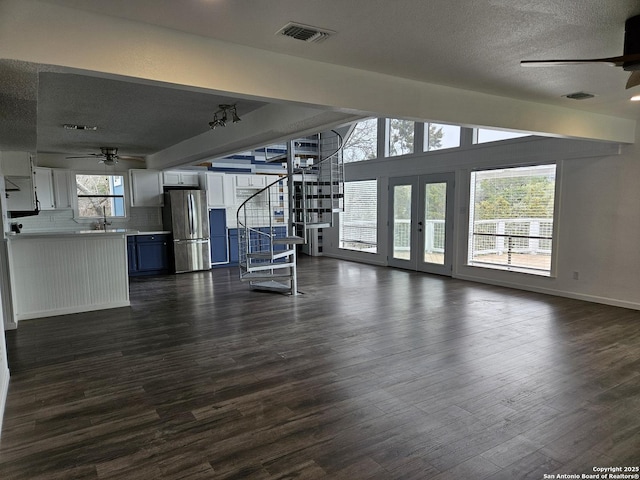 unfurnished living room featuring sink, a textured ceiling, dark wood-type flooring, and ceiling fan