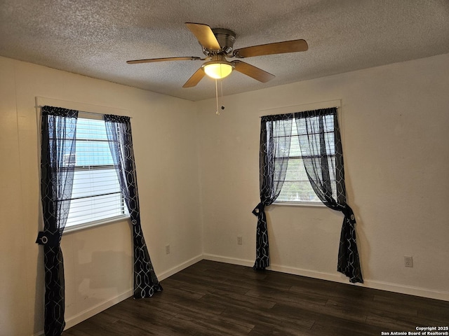 empty room with ceiling fan, dark wood-type flooring, and a textured ceiling