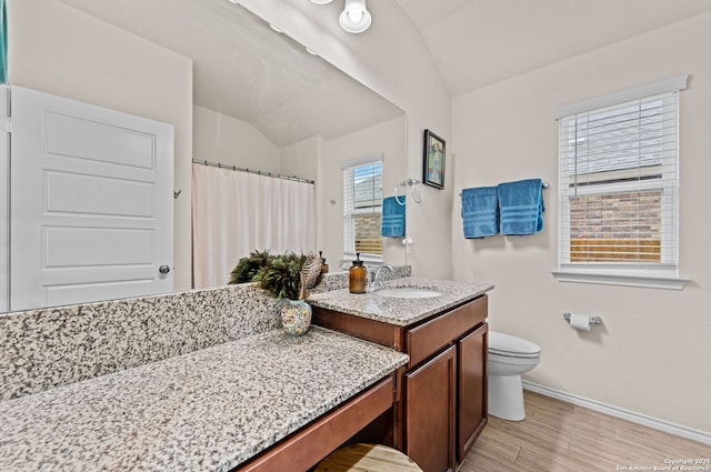 bathroom with lofted ceiling, vanity, hardwood / wood-style floors, and toilet